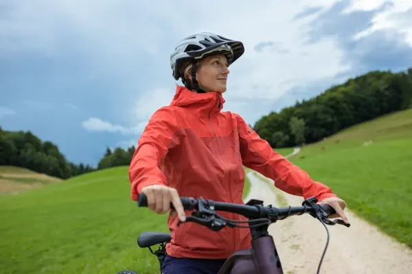 a lady standing aside a bike wearing a helmet